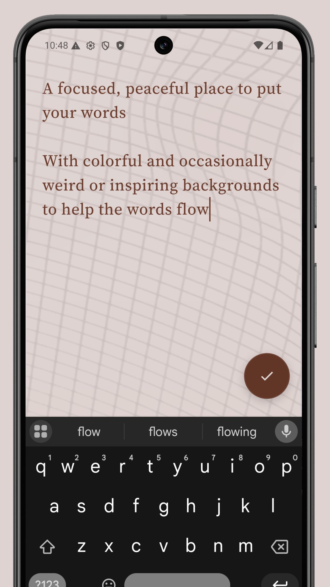 The Loom editor open on a marbled cream paper, the words 'A focused, peaceful place to put your words' visible. The on-screen keyboard is showing autocomplete suggestions; a dark check button confirms the note.